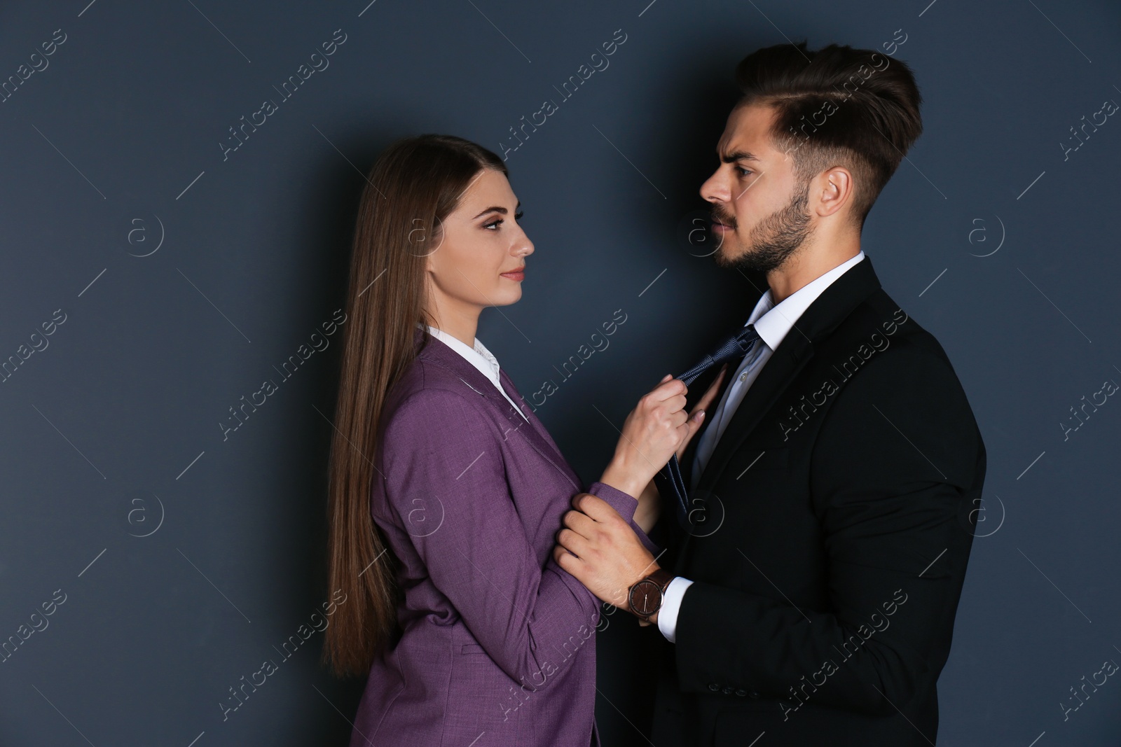 Photo of Woman molesting her male colleague on dark background. Sexual harassment at work