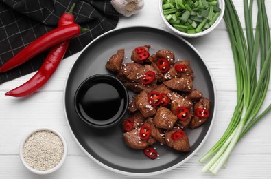 Photo of Plate with tasty soy sauce and roasted meat on white wooden table, flat lay