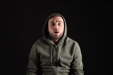 Photo of Portrait of emotional young man on black background. Personality concept