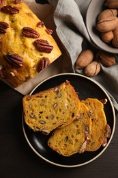 Photo of Delicious pumpkin bread with pecan nuts on wooden table, flat lay