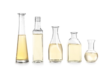 Photo of Row of different glass bottles with oil on white background