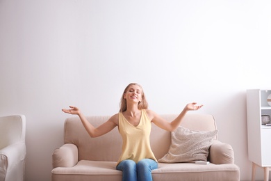 Young woman relaxing under air conditioner at home