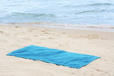 Photo of Blue towel on sandy beach near sea