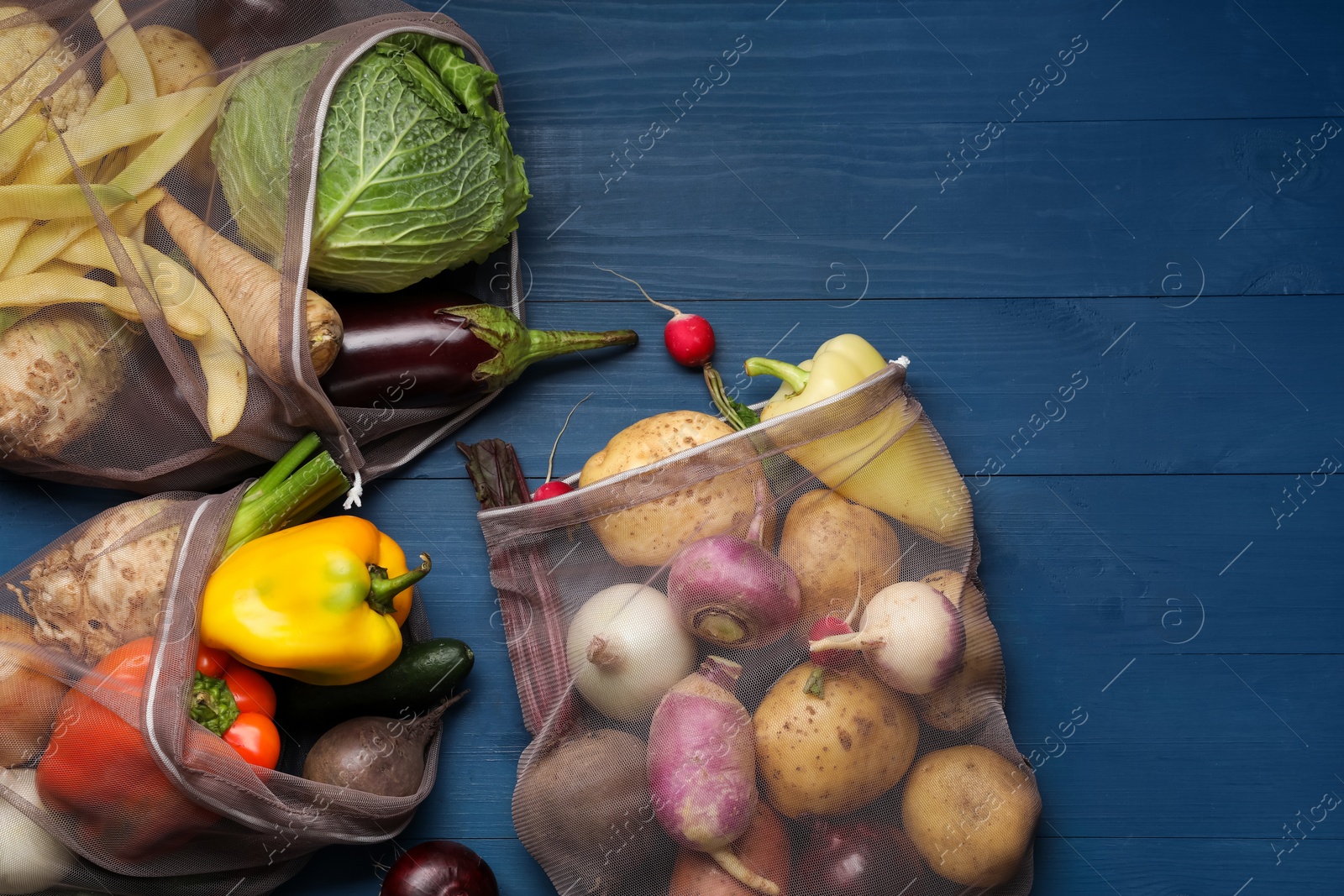 Photo of Different fresh ripe vegetables on blue wooden table, flat lay. Space for text