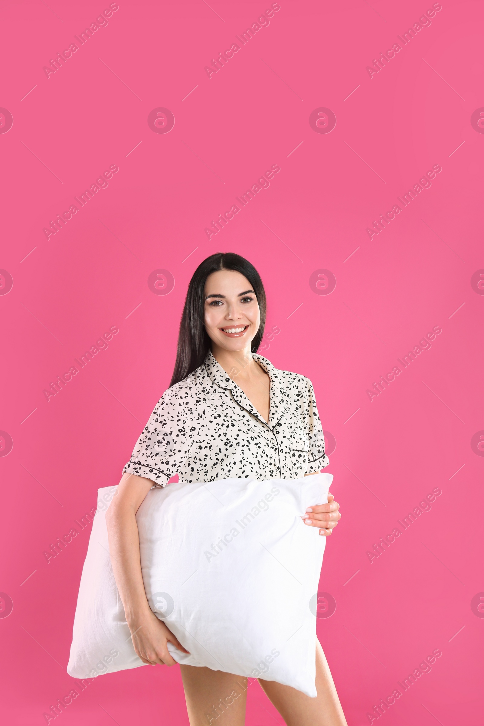 Photo of Young woman with pillow on pink background