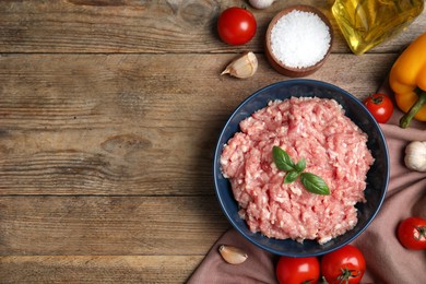 Photo of Raw chicken minced meat and ingredients on wooden table, flat lay. Space for text