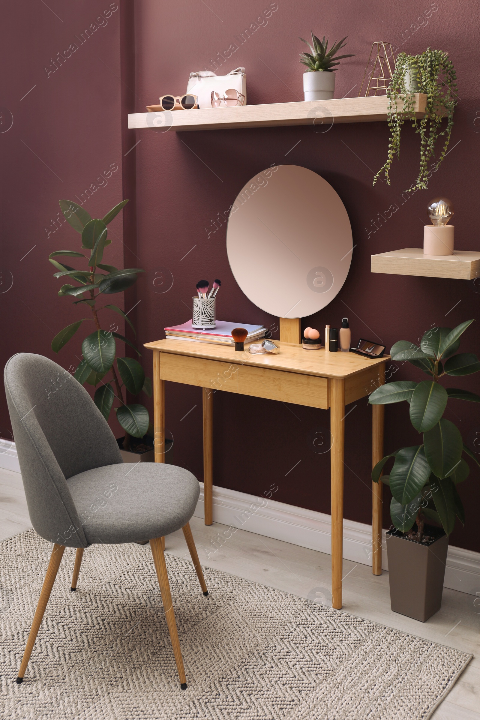 Photo of Wooden dressing table and chair near brown wall in room