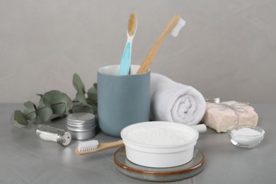 Photo of Composition with tooth powder and brushes on grey table