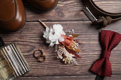 Photo of Wedding stuff. Flat lay composition with stylish boutonniere on wooden background