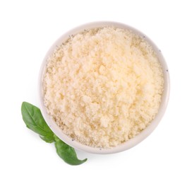 Delicious grated parmesan cheese in bowl and basil on white background, top view