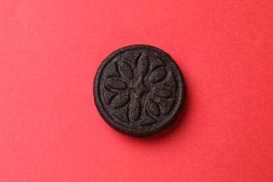 Photo of One tasty sweet sandwich cookie on red background, top view