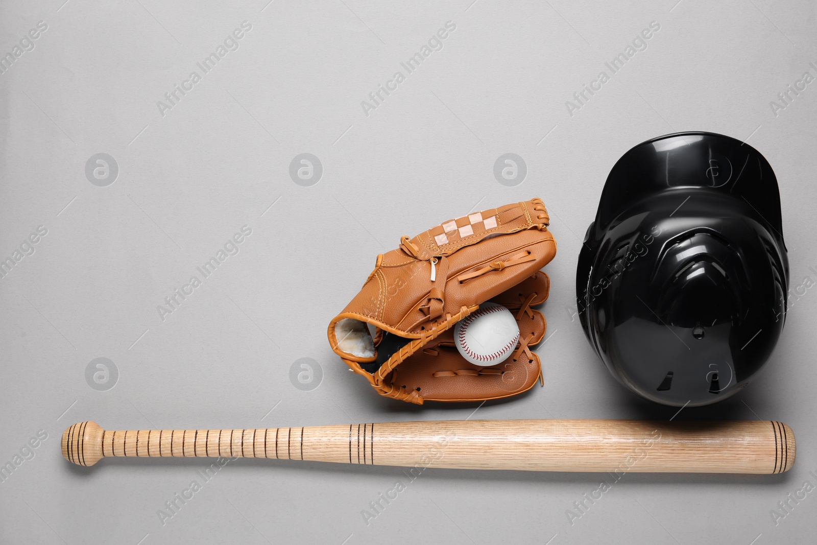 Photo of Baseball glove, bat, ball and batting helmet on light grey background, flat lay. Space for text