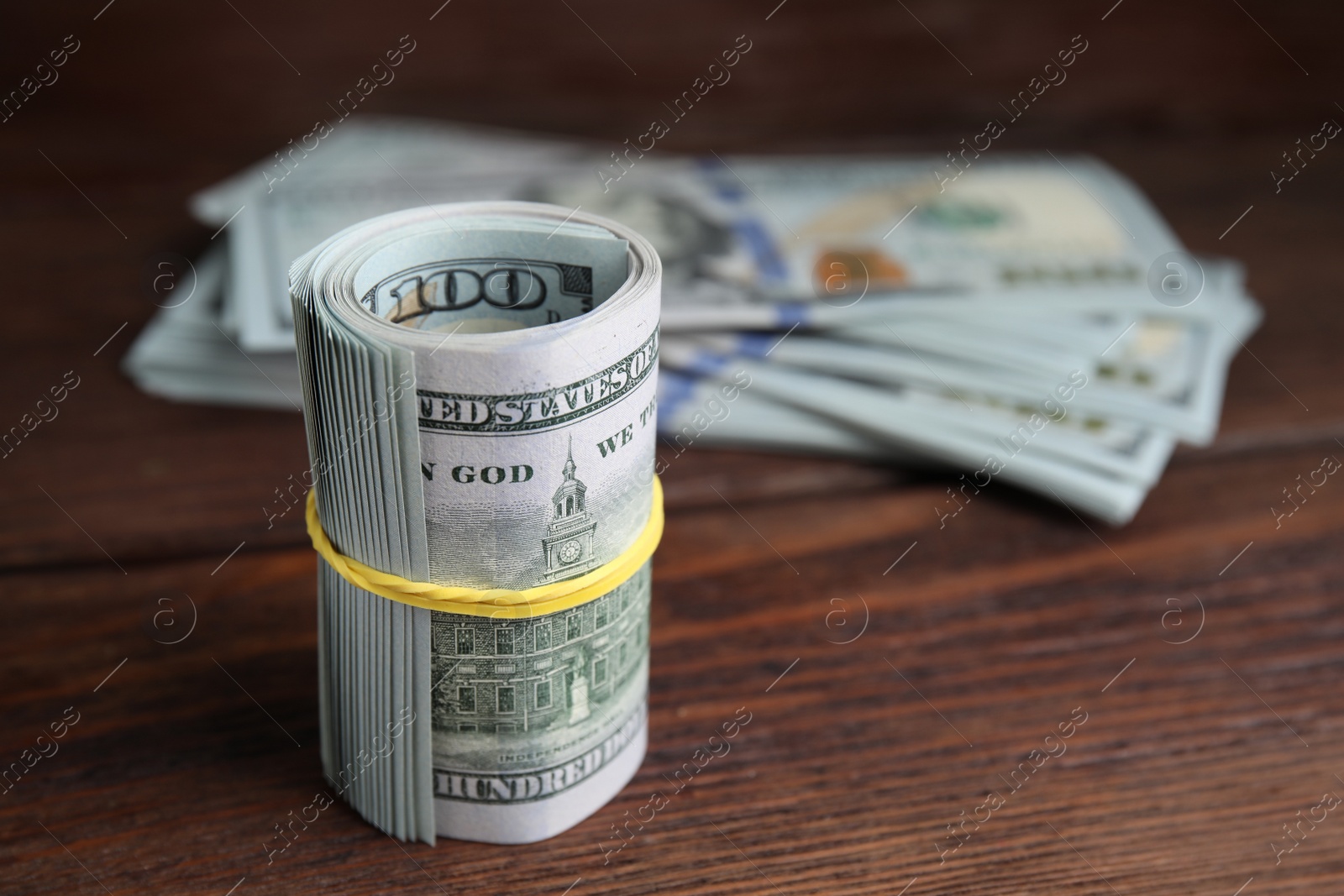 Photo of Many dollar banknotes on wooden table, closeup. Space for text