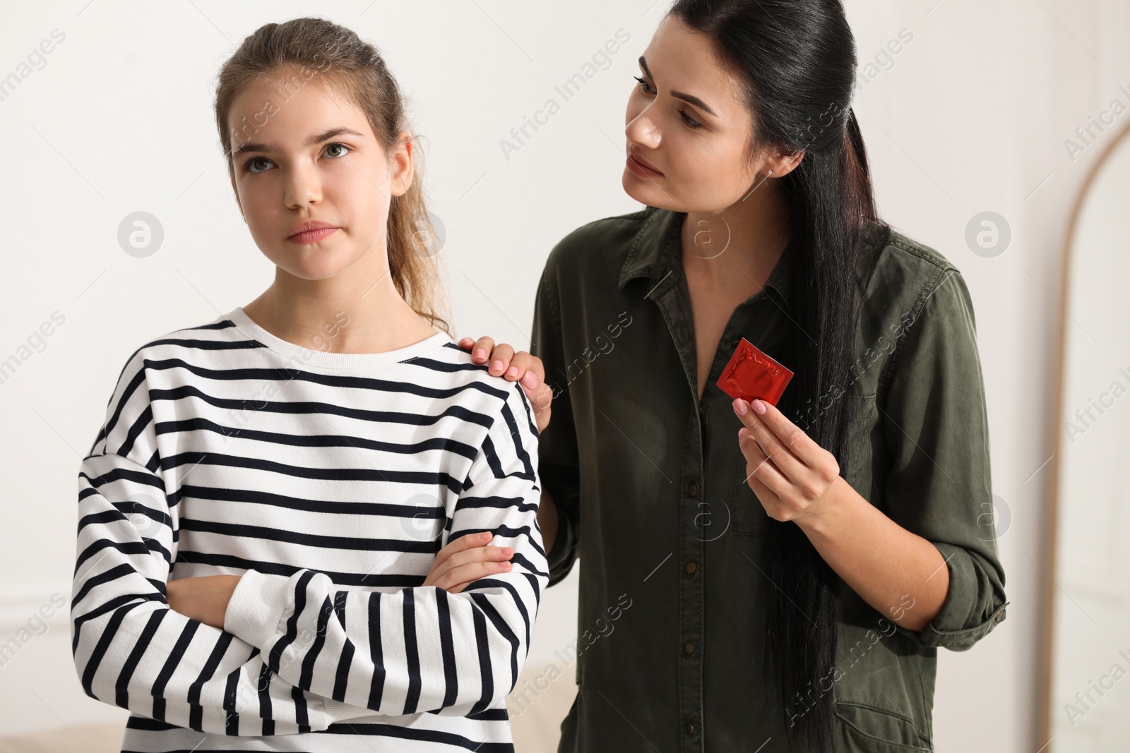 Photo of Mother talking with her teenage daughter about contraception at home. Sex education concept