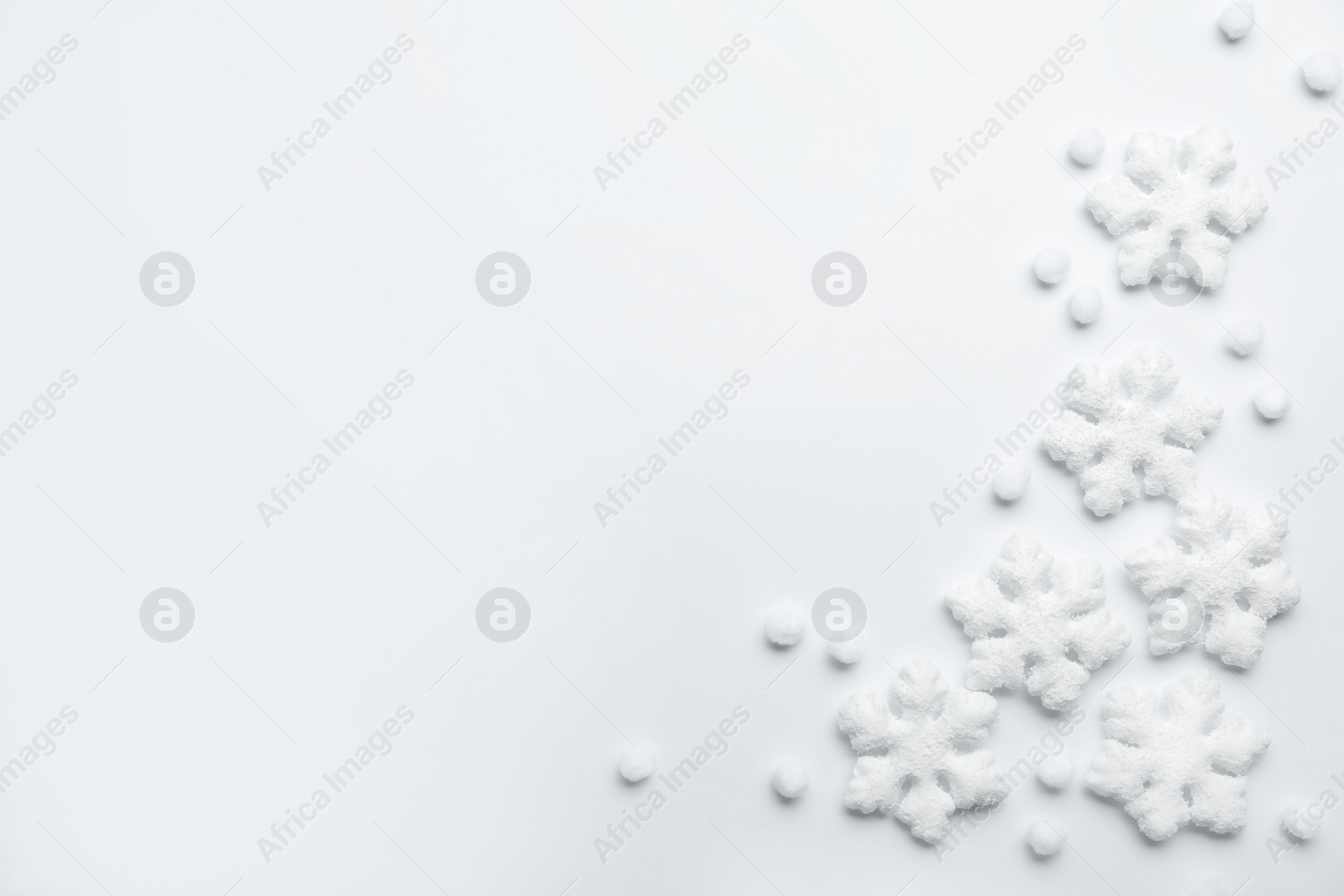 Photo of Beautiful snowflakes and decorative balls on white background, flat lay. Space for text