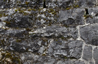 Photo of Stone wall with moss as background, closeup view