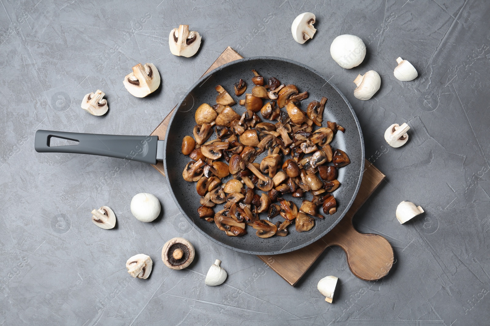 Photo of Frying pan with mushrooms on grey background, flat lay