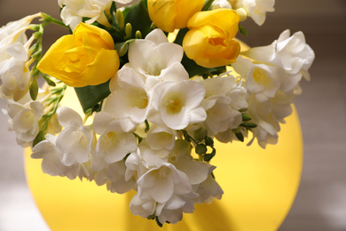 Photo of Beautiful bouquet with fresh freesia flowers on blurred background, closeup