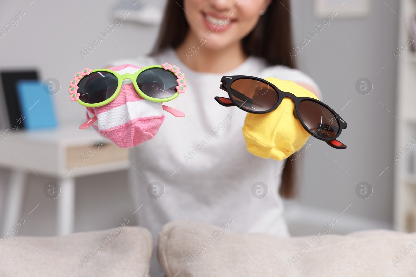 Photo of Happy woman performing puppet show at home, selective focus