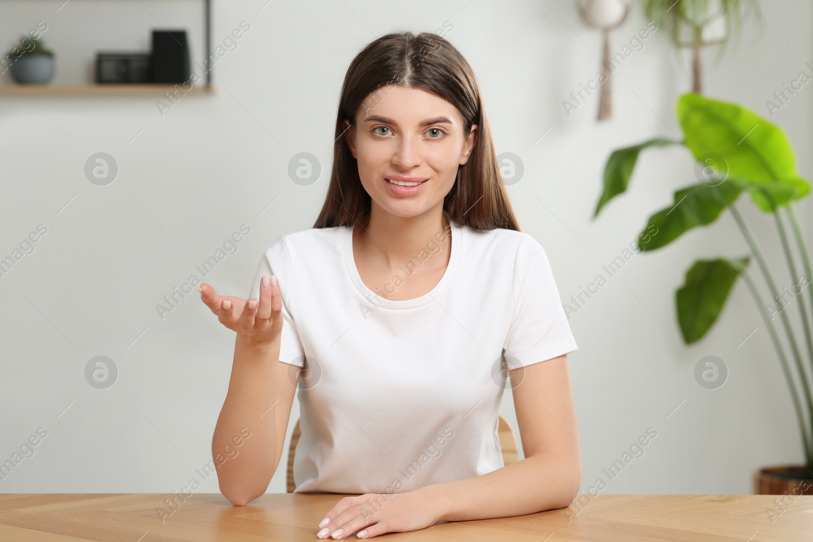 Photo of Happy woman having video call at wooden desk indoors, view from web camera