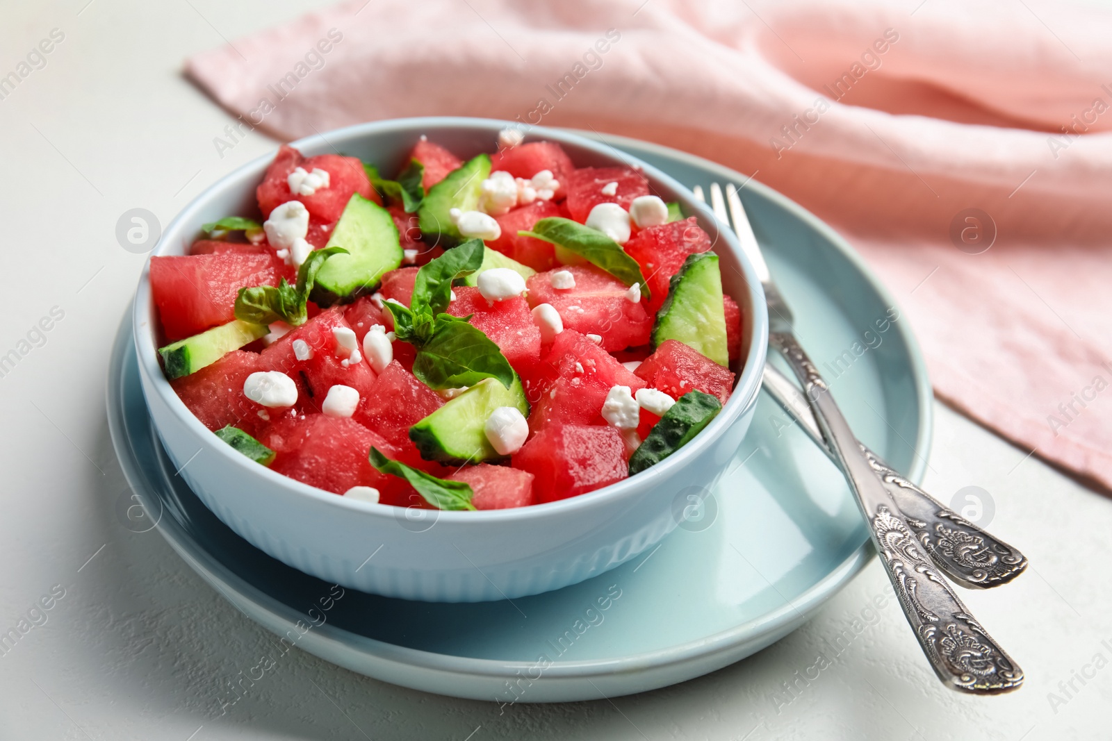 Photo of Delicious salad with watermelon, cucumber and cheese on white table