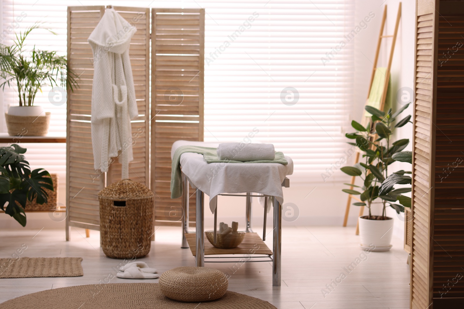 Photo of Comfortable massage table with clean towels in spa center