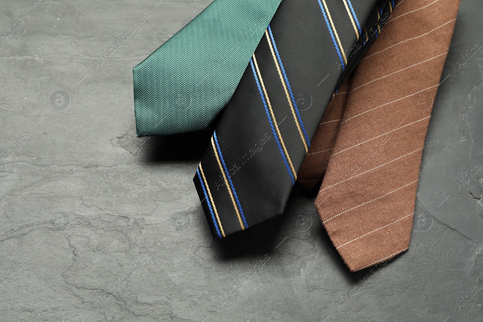 Photo of Different neckties on grey textured background, above view. Space for text