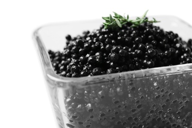 Glass bowl with black caviar on white background, closeup