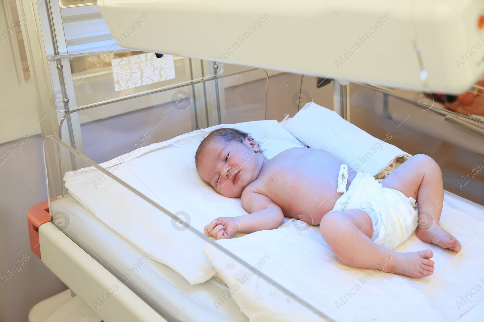 Photo of Newborn child under ultraviolet lamps in hospital