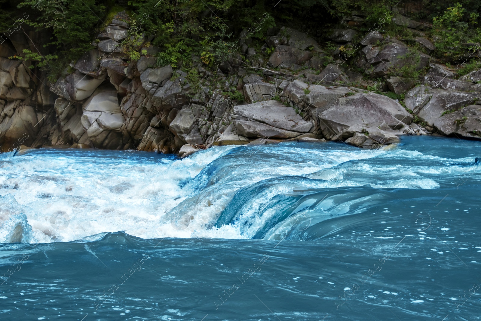 Photo of Mountain river flowing along rocky banks in wilderness