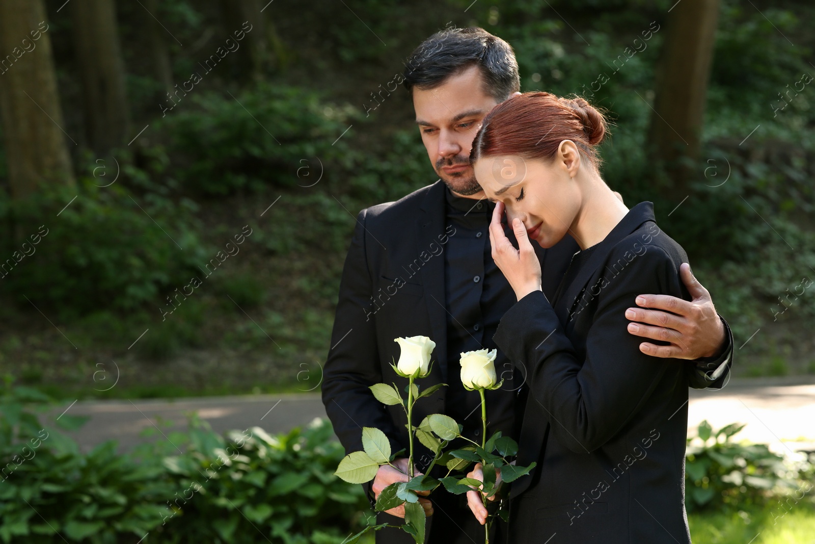 Photo of Funeral ceremony. Man comforting woman outdoors, space for text