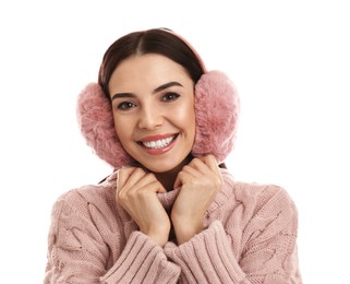 Beautiful young woman wearing earmuffs on white background