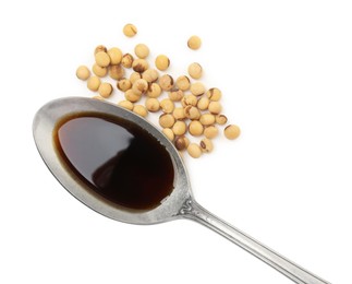 Photo of Tasty soy sauce in spoon and soybeans isolated on white, top view