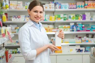 Photo of Professional pharmacist with medicine in modern drugstore