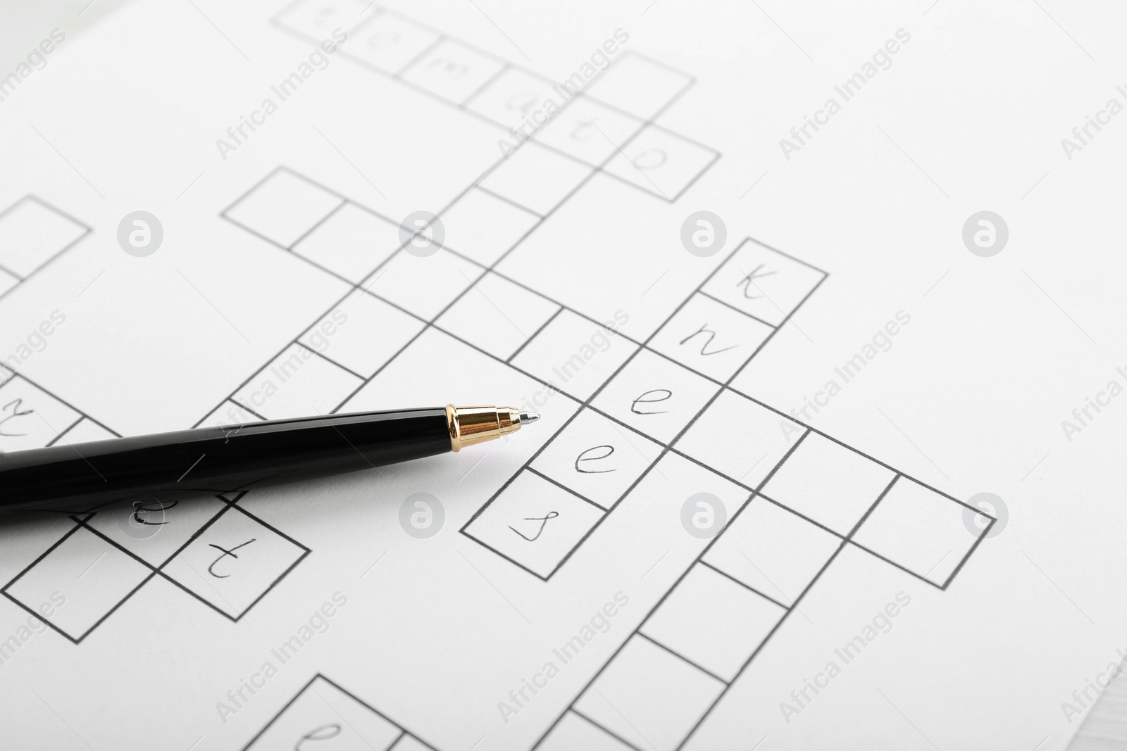 Photo of Crossword with answers and pen, closeup view