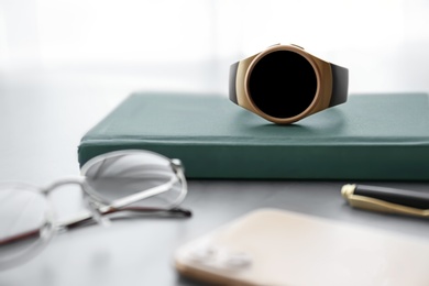 Photo of Composition with stylish smart watch on grey stone table, closeup