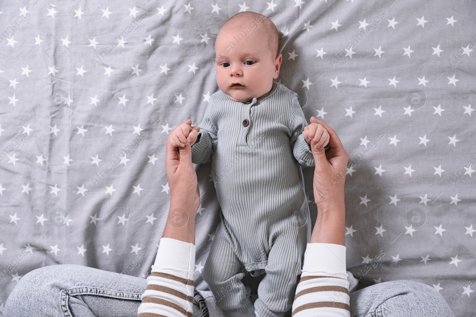 Photo of Mother and her little baby on bed, top view