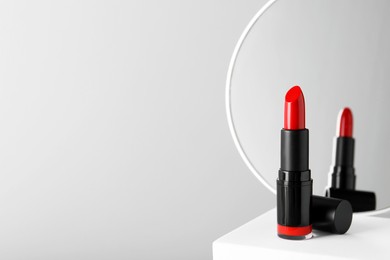 Beautiful red lipstick on light gray background, space for text