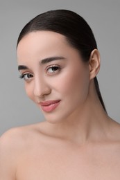 Portrait of beautiful young woman on grey background