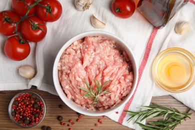Raw chicken minced meat and ingredients on wooden table, flat lay
