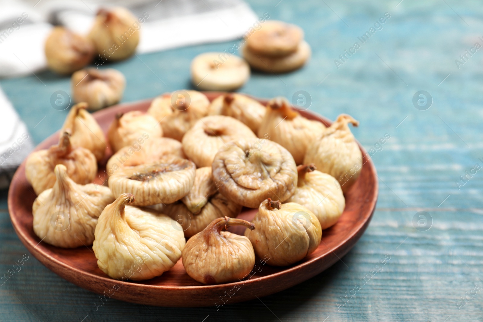 Photo of Tasty dried figs on light blue wooden table, closeup