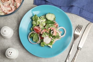 Photo of Plate of delicious vegetable salad dressed with mayonnaise served on light table, flat lay