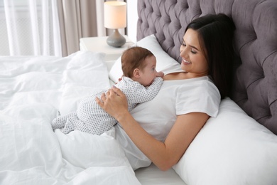 Photo of Happy woman with her cute baby on bed