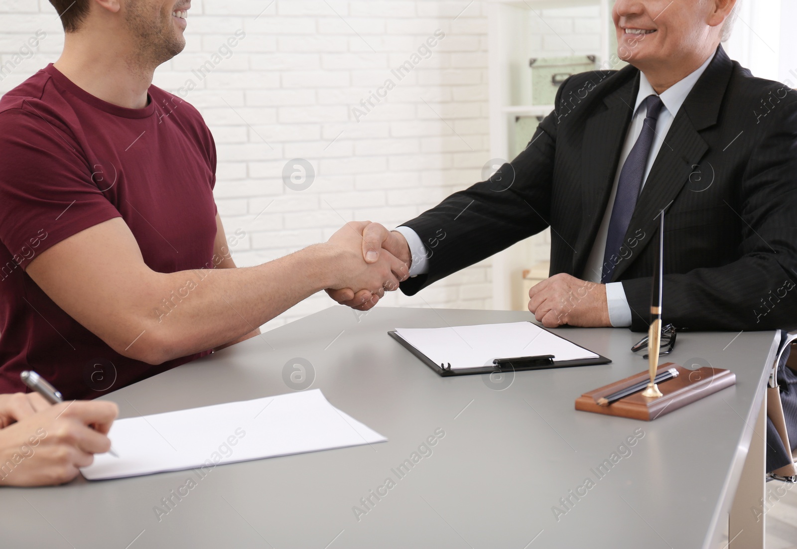 Photo of Lawyer shaking hands with client in office, closeup