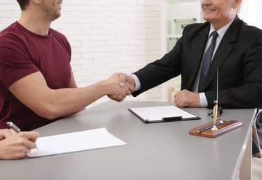 Photo of Lawyer shaking hands with client in office, closeup