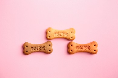 Photo of Bone shaped dog cookies on pink background, flat lay