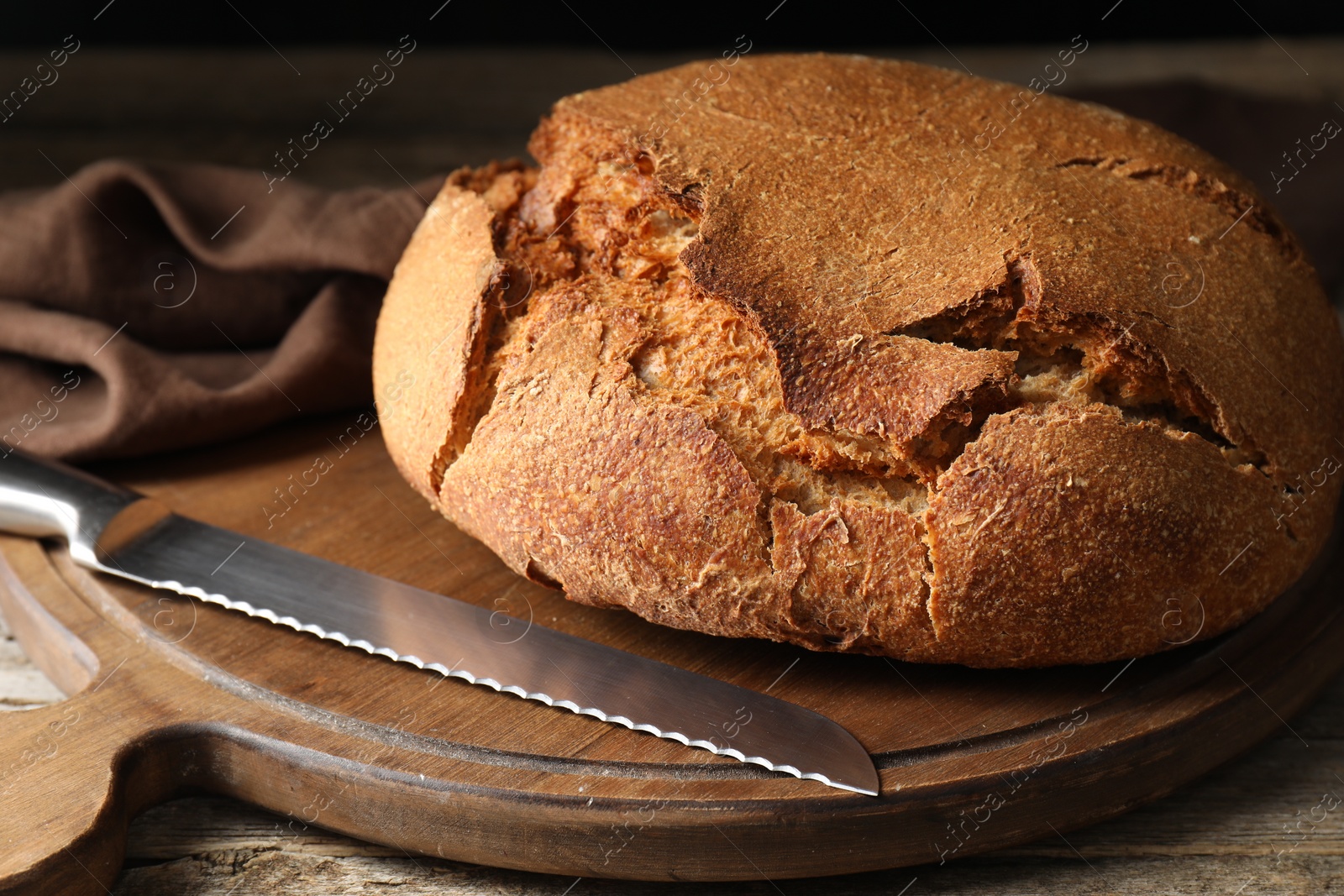 Photo of Freshly baked sourdough bread on wooden table, closeup