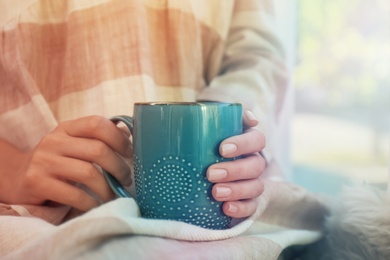 Photo of Woman holding elegant cup indoors, closeup view