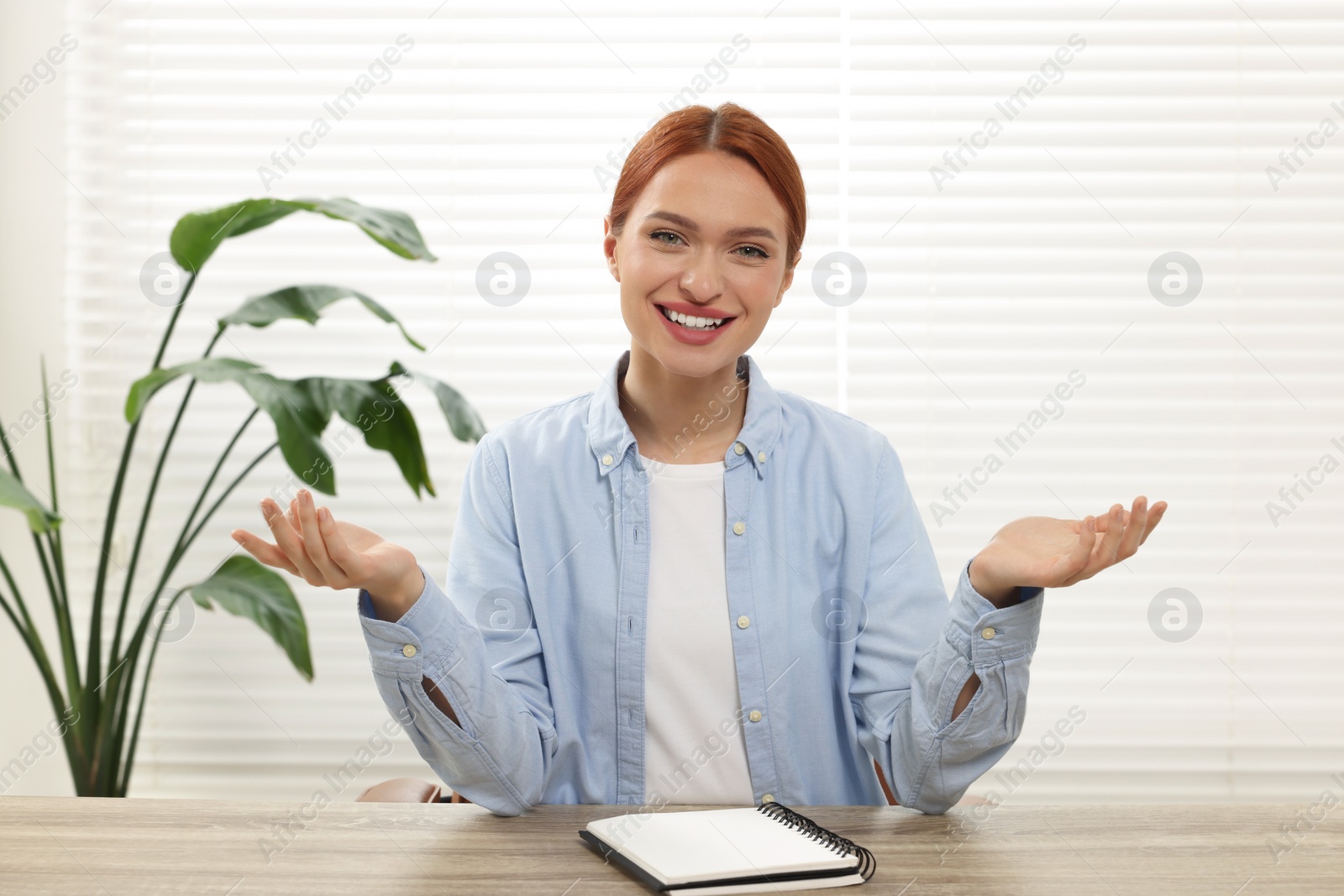 Photo of Young woman having video chat at wooden table indoors, view from web camera