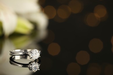 Photo of Beautiful engagement ring against blurred festive lights, space for text